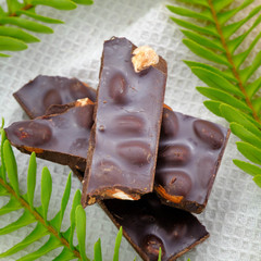 Dark chocolate with almonds (delicious cocoa dessert, pieces of sweets) menu concept. food background. top view.