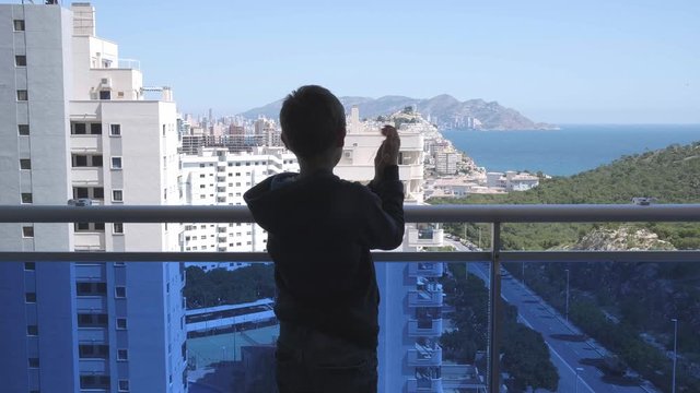 Kid applauding medical staff from their balcony. People in Spain clapping on balconies and windows in support of health workers during the Coronavirus pandemic