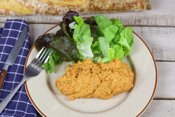 filet américain préparé et salade dans une assiette