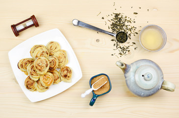 Fototapeta na wymiar Homemade puff pastry cinnamon rolls served with green tea as breakfast, Czech republic, Europe.