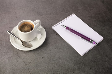 Obraz na płótnie Canvas Coffee cup with a notebook