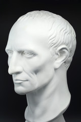 julius caesar roman emperor gypsum bust on black background