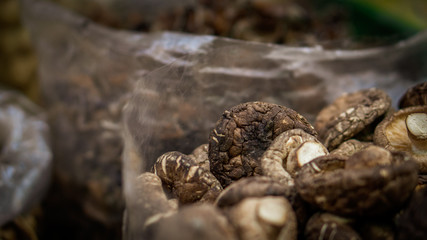 close up of brown and dry mushrooms in a plastic bag for sale