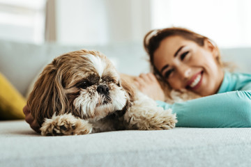 Cute dog and his happy owner relaxing on the sofa.