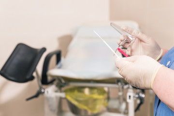 Close-up of doctor hand holds gynecological examination instruments. Gynecologist working in the obstetrics and gynecology department. Medical concept.