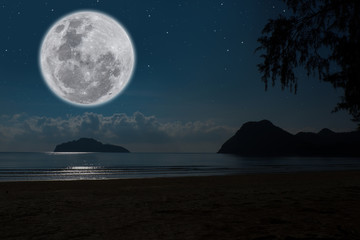 Full moon over sea at night.