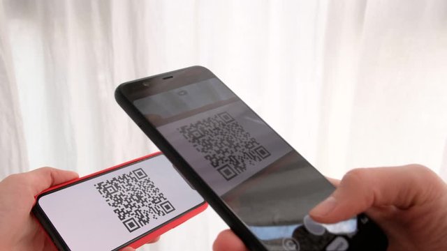 One person presents a smartphone with QR code pass to another person who checks the route white background