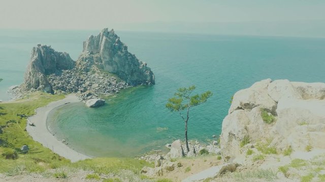 Aerial View of the Baikal Bay Shamanka. White ship in calm bay at great lake. Olkhon Island, Baikal, Russia, Siberia. Drone footage. UNESCO World Heritage Site