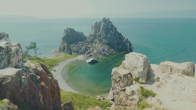 Aerial View of the Baikal Bay Shamanka. White ship in calm bay at great lake. Olkhon Island, Baikal, Russia, Siberia. Drone footage. UNESCO World Heritage Site
