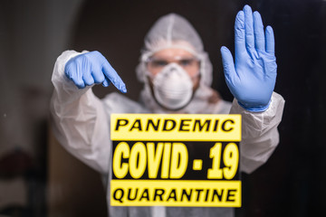 Man in protective suit and in protective medical mask showing stop gesture. Epidemiologist show stop palm. Stop coronavirus or covid-19 and the pandemic. Stay home. Quarantine concept.