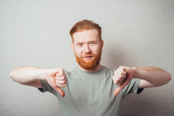 bearded man showing thumbs down