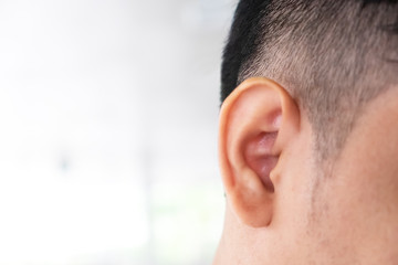 Close up of the right ear of a man and the place on the left side for placing letters.