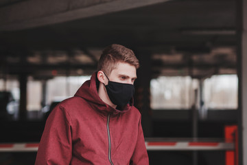 Concept of coronavirus quarantine. Novel coronavirus (2019-nCoV), man with black face mask in city