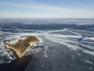 Fototapeta premium Aerial view with an island on the Onega lake covered with ice, northwest of Russia