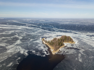 Aerial view with an island on the Onega lake covered with ice, northwest of Russia