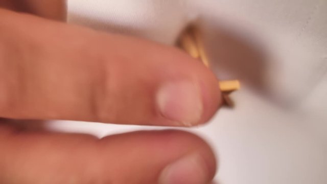 Male wearing David Star shaped golden cufflink on white shirt. Close up