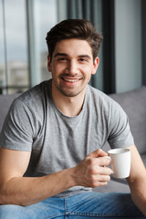 Man indoors at home drinking coffee.