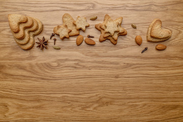 Fototapeta na wymiar Background with homemade cakes, fragrant cookies. Cookies in the form of hearts, stars, coffee beans, spices, almonds close-up. menu concept, Home baking. Full size