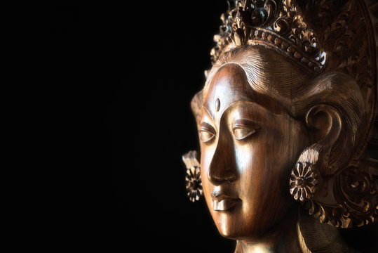 Parvati goddess face. Also known as Uma or Gauri is the Hindu goddess of fertility, love, beauty, marriage, children, and devotion. Wooden sculpture from Ubud Bali. Woodcarving, handcraft.