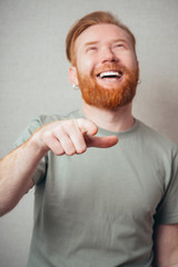 Laughing man with beard pointing at camera