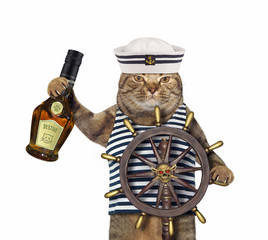 The beige cat in a sailor uniform with a bottle of rum is at the helm of the ship. White...