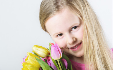 Fototapeta premium Smiling blond girl with a bouquet of tulips.