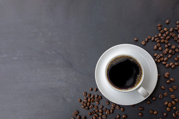 cup of coffee and bean on black wooden table background. top view