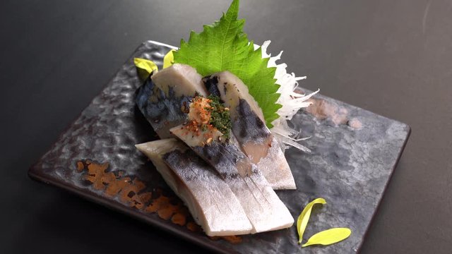 Sliced Japanese food saba sashimi dinner meal on a turn table .