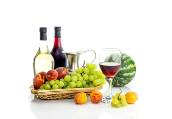 Summer fruit and bottles of wine on a white background close-up