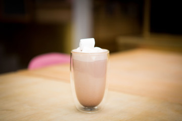 hot cocoa with marshmallows on a light wooden table