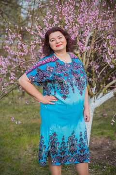 Middle Age Plus Size Woman Enjoying In Ethnic Dress. A Mature Lady With Excess Weight, Stylishly Dressed. Natural Beauty