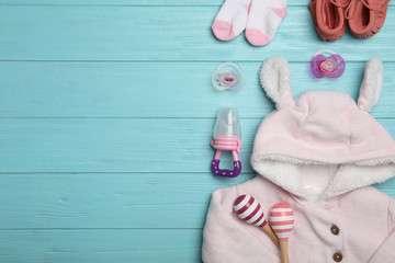 Flat lay composition with child's clothes on light blue wooden table, space for text