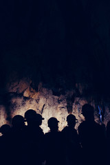 Silhouette of tourists visiting a cave. 