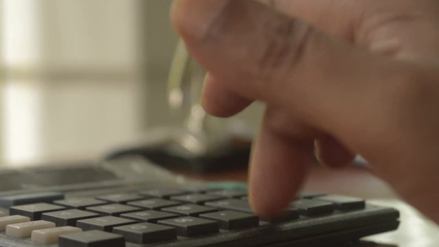 A businessman typing hand calculating numbers. Fingers pressing the buttons of calculator. Close up of Press the right button. Calculator with finger. Counting on vintage background isolated.