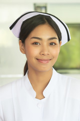 portrait of smiling asian woman nurse isolated; studio shot of confident friendly successful professional female nurse or medical worker