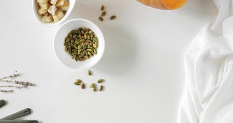Stop motion animation Pumpkin soup, a piece of pumpkin, seeds and crackers. A plate is spinning on an empty table 4K - Powered by Adobe
