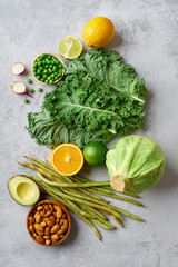 Top view flat lay with healthy vegetarian food ingredients. Raw food concept with avocado. Organic fruits and vegetables on concrete background with copy space.