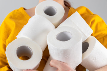 Female hands hold many rolls of toilet paper for their intended use. Hygiene and body care