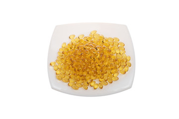 Softgels of Omega-3 on a white plate. Vitamins fish oil on a white background. Yellow capsules with medicine. Meal replacement. Medical medicament of polyunsaturated fatty acids. top view