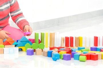 Home games for kids. Creative child play with wooden toy building blocks in home during coronavirus.