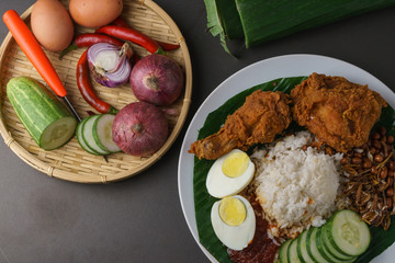 Nasi Lemak-Malaysian cuisine. A fragrant rice dish cooked in coconut milk and pandan leaf commonly found in Malaysia. Served with sambal, anchovies, peanut and cucumber.