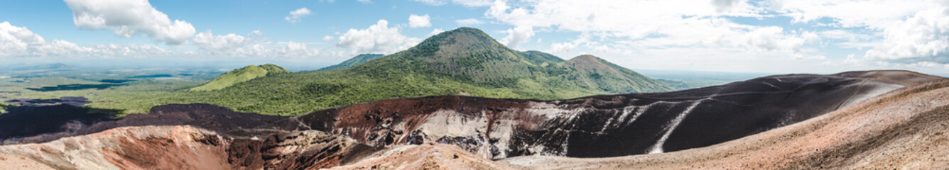 Panoramic view over a volcanic crater and lush green mountains around Cerro Negro, an active...