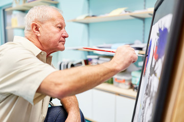 Senior Mann mit Demenz malt ein Bild