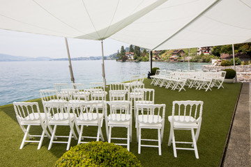 Outdoor preparation for event, white chairs on yard