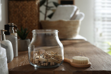 Obraz na płótnie Canvas Jar with clothespins and shower brush on shelf indoors. Bathroom interior elements