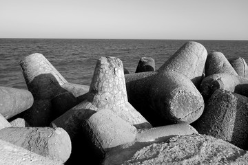 Fototapeta na wymiar Breakwater stones on mole at Black sea in black and white.
