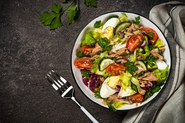 Tuna salad with green leaves, eggs and vegetables.