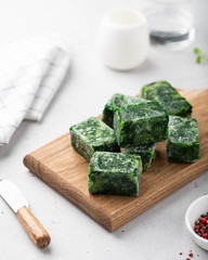 frozen spinach on a wooden board on a light background 