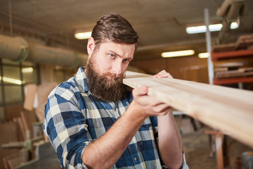 Carpenter checks the quality of timber
