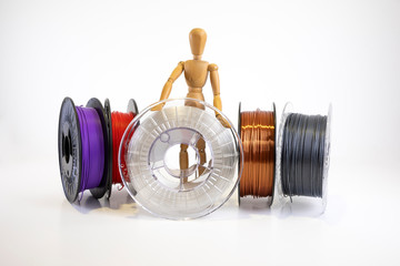 3D printing filament reels with wooden anthropomorphic doll on white background